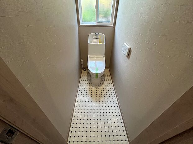 小窓から光が差し込む明るいトイレ空間。デザイン性のある床材がアクセントになっています。