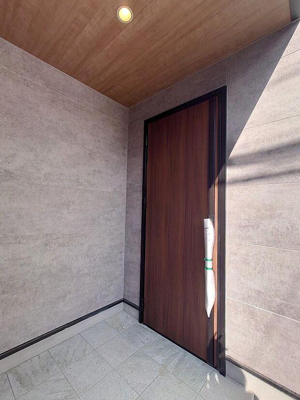 プライバシー性の高い玄関は天井にダウンライトと木目をあしらい、スマートキーでスタイリッシュな生活をさらに便利に。