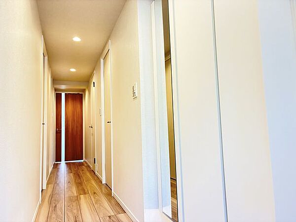木目のやさしい風合いとホワイトの清潔感が調和する廊下。ナチュラルな色合いが空間に穏やかな表情を添え、住まい全体を心地よくつなぎます。