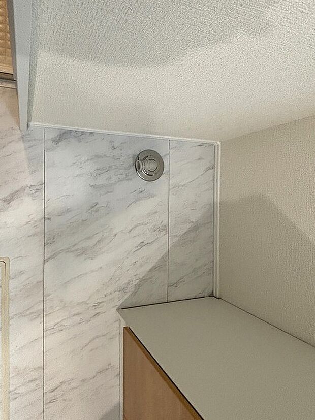 清潔感ある大理石調の壁と、温かみのある素材が調和する空間。