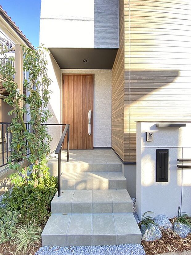 アプローチからの玄関がおしゃれな住宅。出発も帰宅も楽しみになるかも。 