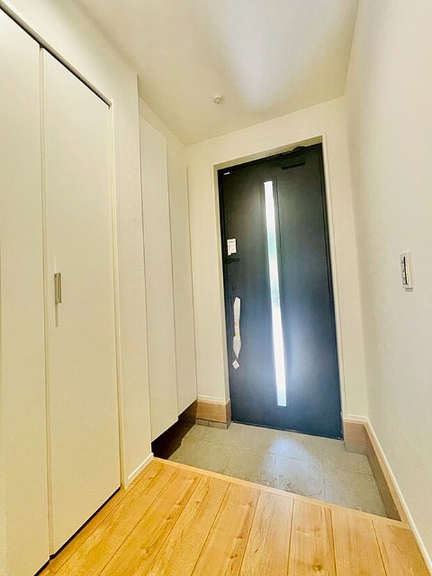 白を基調としたすっきりとした空間に、濃い色合いの扉が引き立つ洗練された佇まいです。
