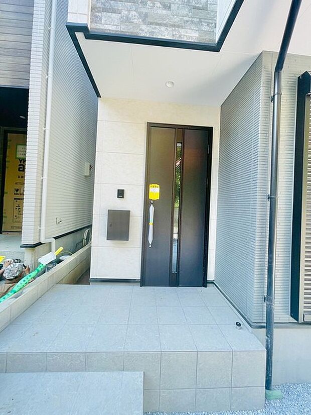 ポーチのついた新築分譲物件。玄関の印象はいかがでしょうか？入口からご覧ください。 