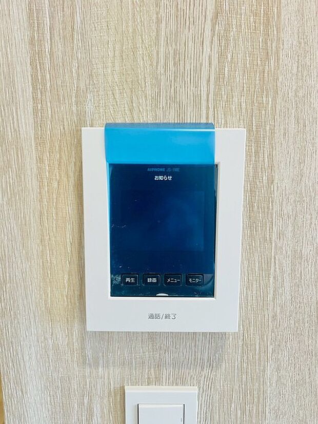 温もりを感じる木目調の壁に、洗練されたインターホンが調和する空間