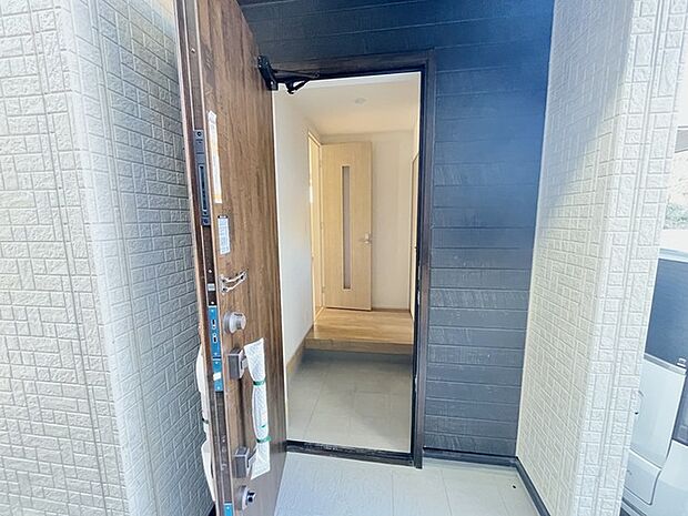 木の温もりと石の質感が調和する、落ち着きのあるエントランス。