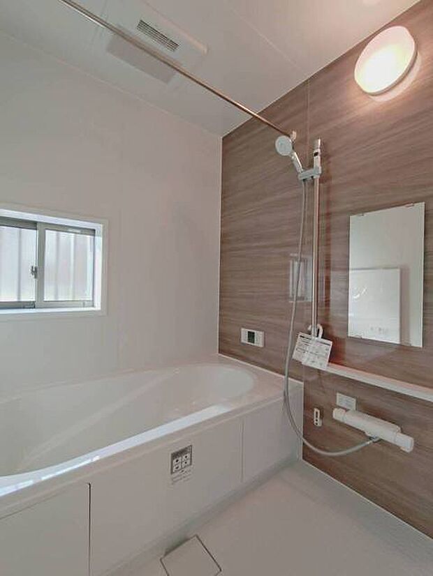 落ち着いた木目調の壁に囲まれた、くつろぎのバスルーム。