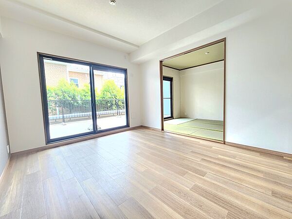 広々とした空間に、隣接する和の趣ある空間。自然な木目調の床と、鮮やかな緑が映える窓辺が、心地よい静けさと開放感をもたらします。一日を通して穏やかな時間が流れる、穏やかな住まいです
