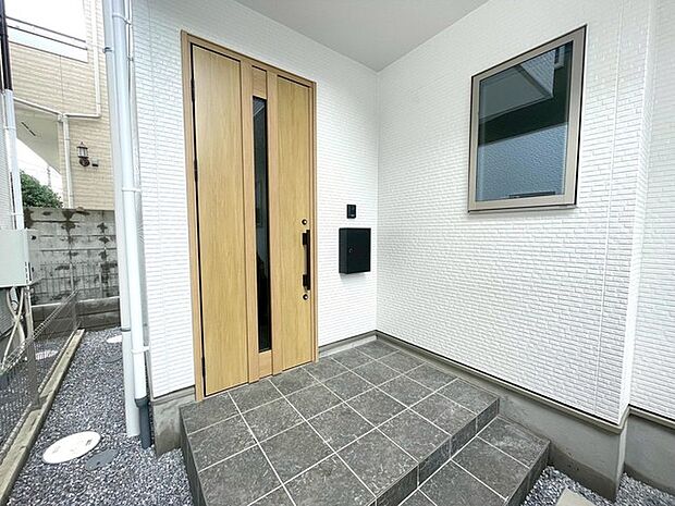 ポーチのついた新築分譲物件。玄関の印象はいかがでしょうか?入口からご覧ください。