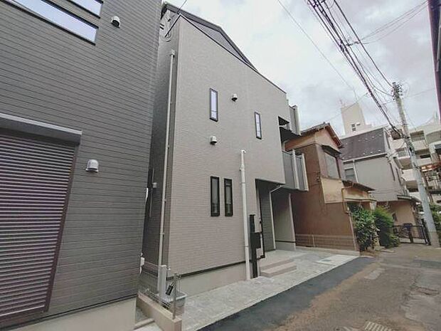 落ち着いた色合いの外観が周囲の街並みに調和する洗練された佇まい