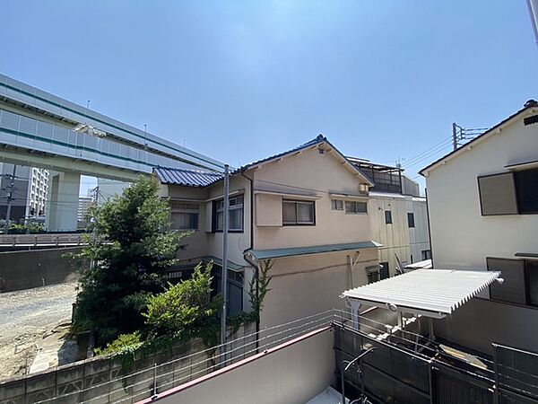 青い空が広がり、穏やかな時間が流れる住宅街の落ち着いた風景です。