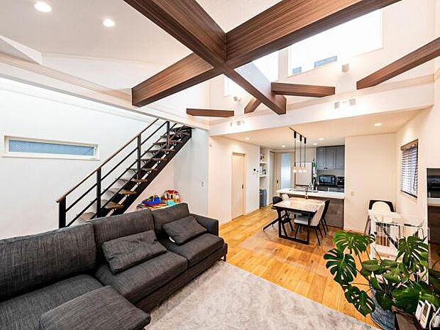 【勾配天井とスケルトン階段が開放感により拍車をかける心地よい寛ぎの家】大きな高窓からは暖かい日差しが届く。化粧梁とスポットライトが瀟洒（建物プラン例 建物価格／2300万円 建物面積／97.50m2）
