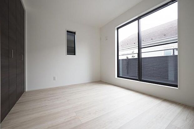 2階6.5帖洋室。バルコニーから優しい光が差し込む室内。