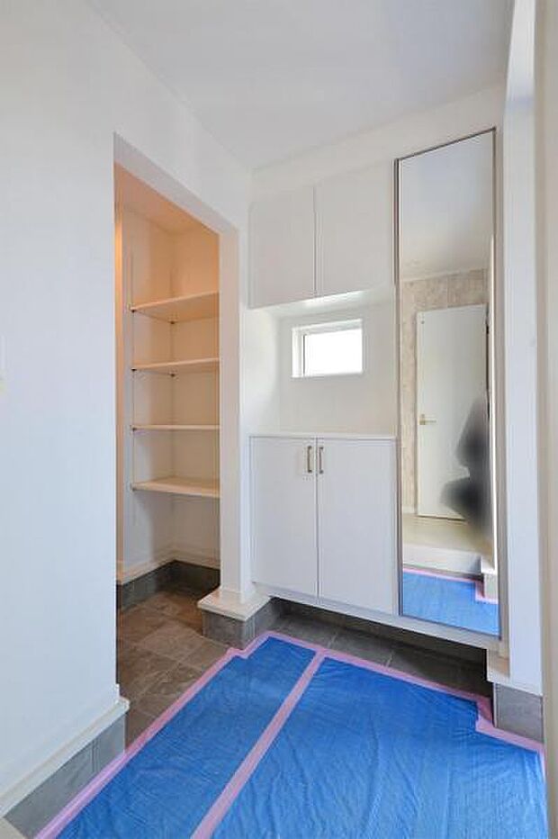 自然光が入る小窓のある玄関。姿見付きのシューズボックスで、使い勝手も◎