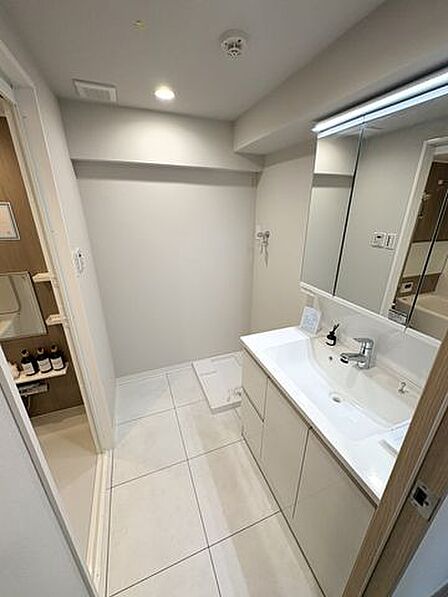 白を基調とした清潔感のある洗面室。玄関近くに配置された洗面室は帰宅後の手洗いに便利です。