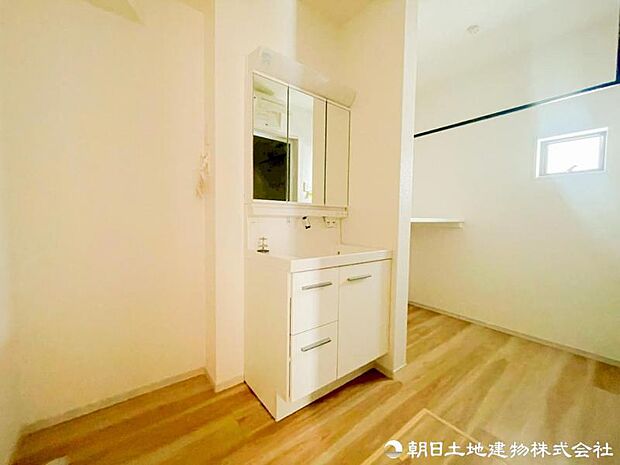 【洗面化粧台】 三面鏡裏収納付き洗面化粧台。身支度用品をすっきり収納でき、脱衣スペースも広く確保された快適な洗面空間です。