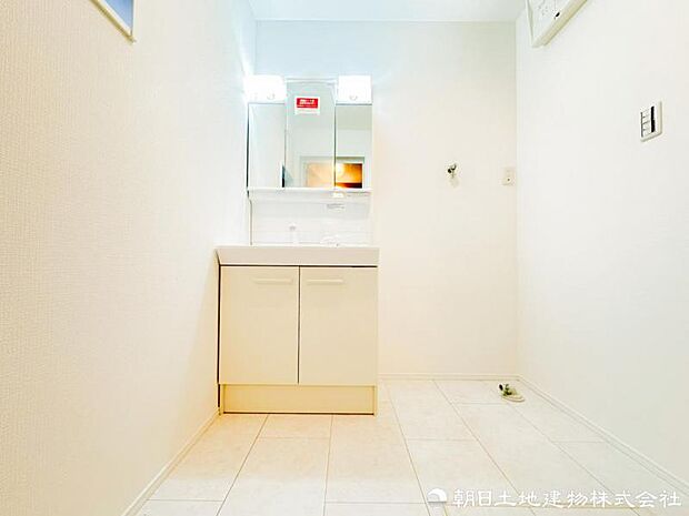 【洗面化粧台】 三面鏡裏収納付き洗面化粧台。身支度用品をすっきり収納でき、脱衣スペースも広く確保された快適な洗面空間です。