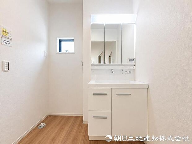 【洗面化粧台】 三面鏡裏収納付き洗面化粧台。身支度用品をすっきり収納でき、脱衣スペースも広く確保された快適な洗面空間です。