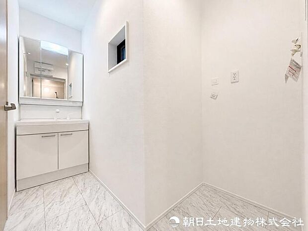 【洗面化粧台】 三面鏡裏収納付き洗面化粧台。身支度用品をすっきり収納でき、脱衣スペースも広く確保された快適な洗面空間です。