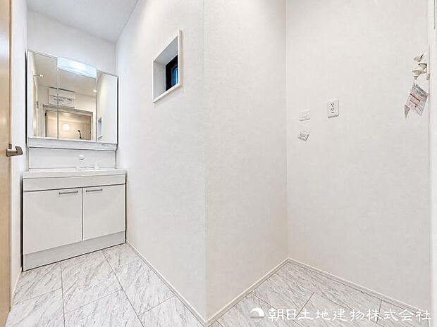 【洗面化粧台】 三面鏡裏収納付き洗面化粧台。身支度用品をすっきり収納でき、脱衣スペースも広く確保された快適な洗面空間です。