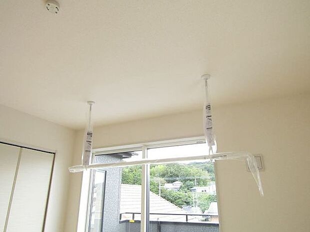 洋室に設置された室内物干し機で、天候を気にせず洗濯物を干すことができます。
