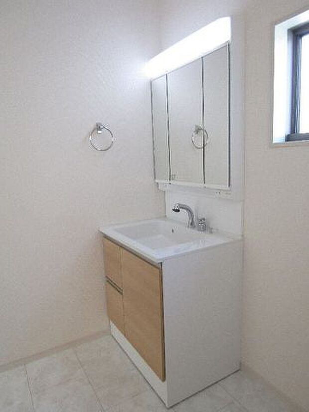 三面鏡の洗面化粧台は鏡扉の裏収納でたっぷりの容量をスッキリと収納できます。シャワーヘッド付きでお掃除も楽ちんです。