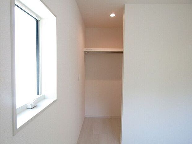 ハンガーパイプの上に棚があり、衣類と小物をすっきり収納可能なウォークインクローゼットです。