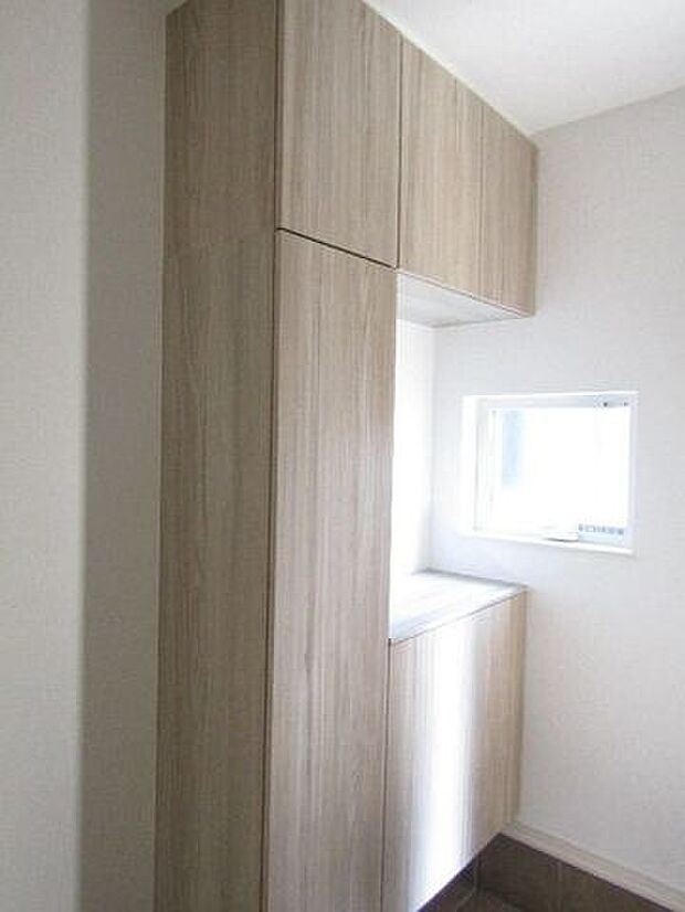 家族みんなの靴をたっぷり収納できるシューズボックス付き。中央に鍵や季節の飾りを置ける便利なスペース付き。