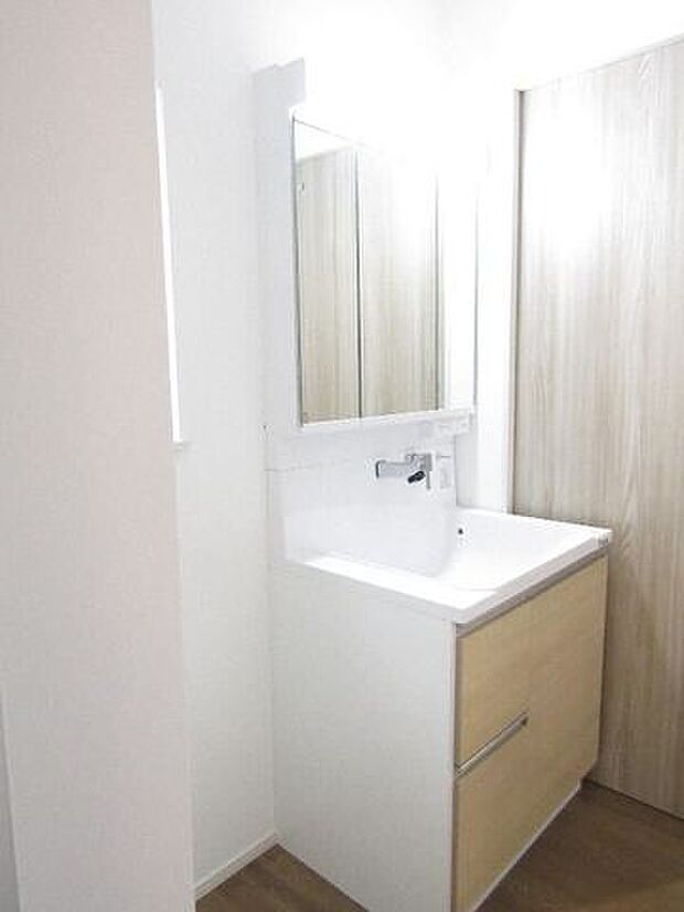 三面鏡の洗面化粧台は鏡扉の裏収納でたっぷりの容量をスッキリと収納できます。シャワーヘッド付きでお掃除も楽ちんです。