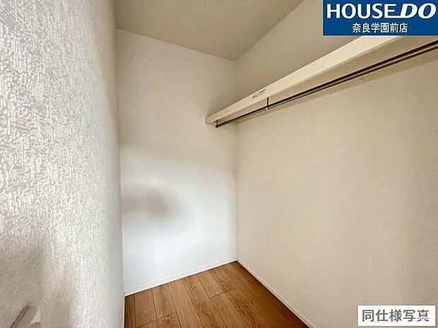 ハンガーパイプの上に棚があり、衣類と小物をすっきり収納可能なウォークインクローゼットです。