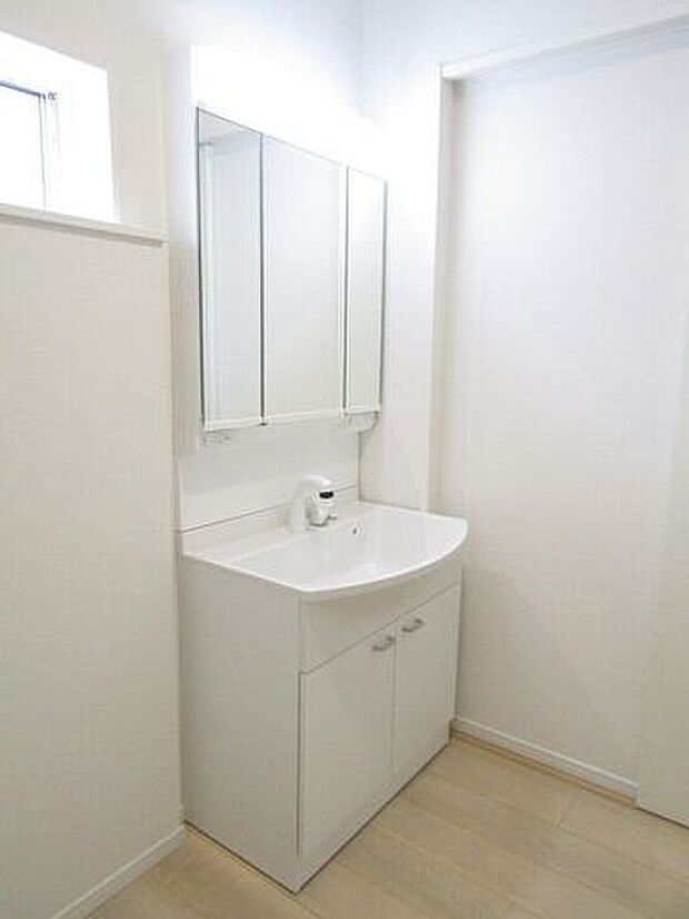 三面鏡の洗面化粧台は鏡扉の裏収納でたっぷりの容量をスッキリと収納できます。シャワーヘッド付きでお掃除も楽ちんです。