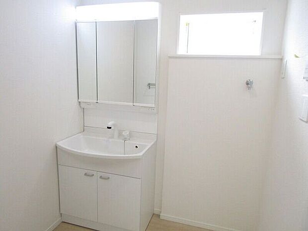 三面鏡の洗面化粧台は鏡扉の裏収納でたっぷりの容量をスッキリと収納できます。シャワーヘッド付きでお掃除も楽ちんです。