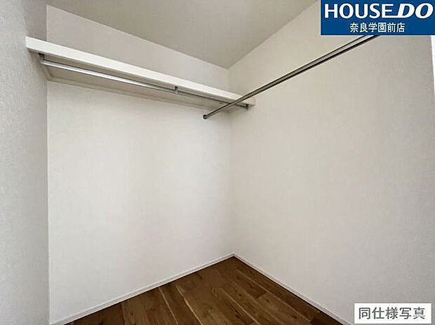 ハンガーパイプの上に棚があり、衣類と小物をすっきり収納可能なウォークインクローゼットです