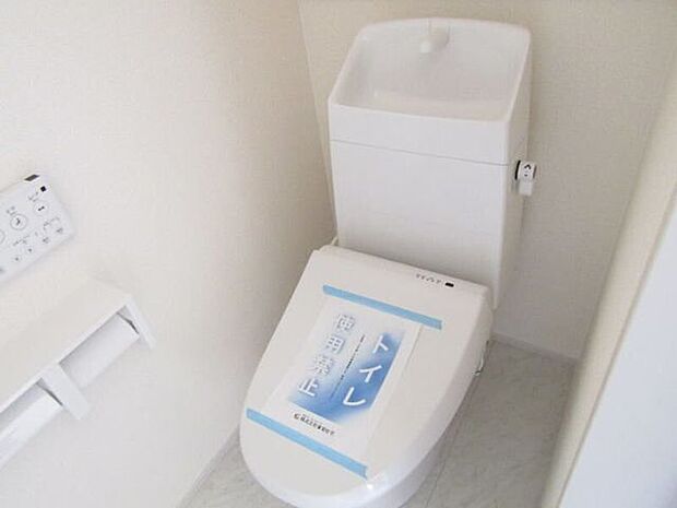 洗浄便座付きの快適トイレ。壁面収納で備品をすっきり整理でき、手すり付きで立ち座りも安心です。