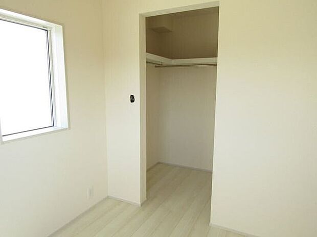 ハンガーパイプの上に棚があり、衣類と小物をすっきり収納可能なウォークインクローゼットです。