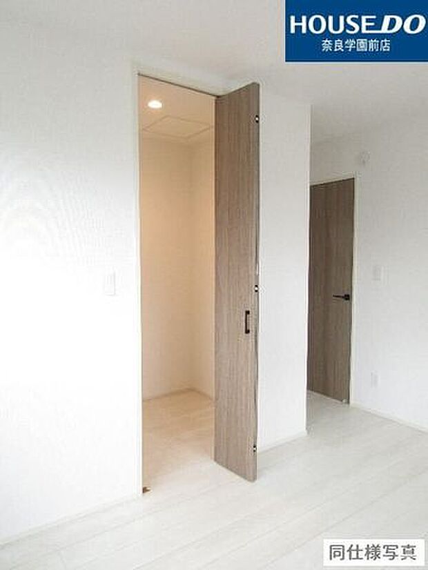 ハンガーパイプの上に棚があり、衣類と小物をすっきり収納可能なウォークインクローゼットです。