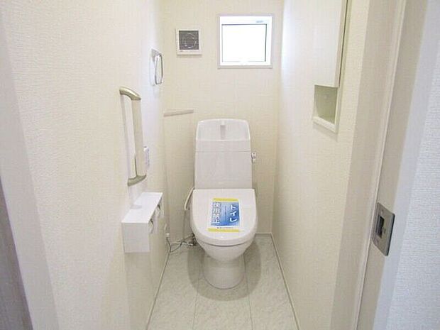 洗浄便座付きの快適トイレ。壁面収納で備品をすっきり整理でき、手すり付きで立ち座りも安心です。