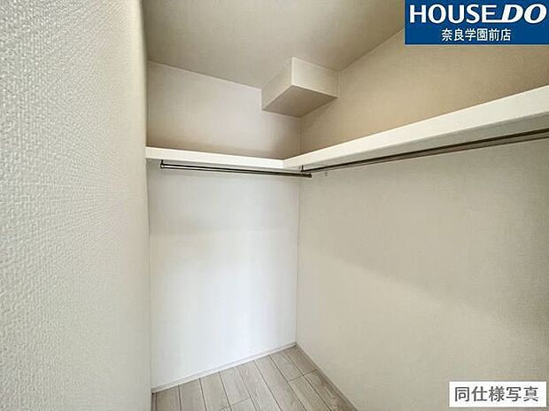 ハンガーパイプの上に棚があり、衣類と小物をすっきり収納可能なウォークインクローゼットです。