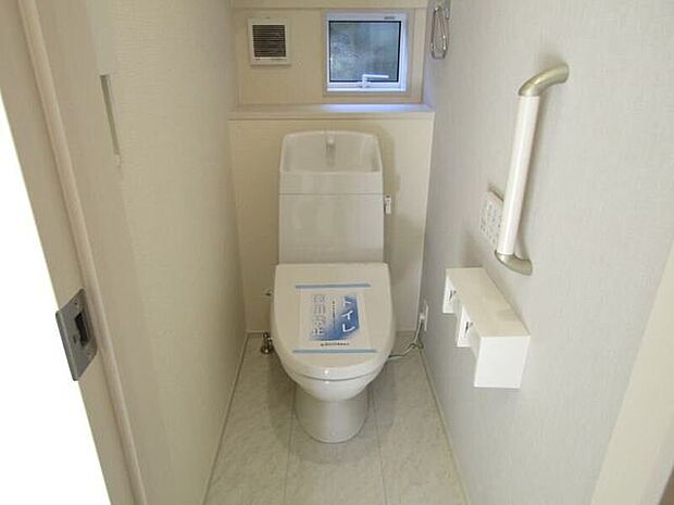 洗浄便座付きの快適トイレ。壁面収納で備品をすっきり整理でき、手すり付きで立ち座りも安心です。