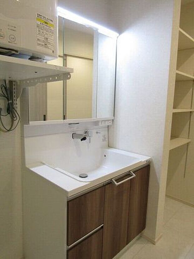 洗面台にはシャンプードレッサーを採用。収納棚も設置しており、タオルや洗剤、日用品などをすっきりと収納できます。