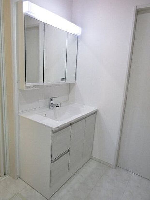 三面鏡の洗面化粧台は鏡扉の裏収納でたっぷりの容量をスッキリと収納できます。シャワーヘッド付きでお掃除も楽ちんです。