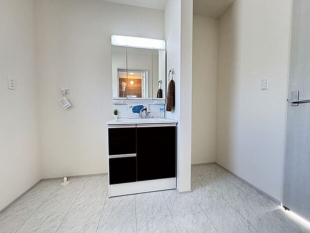 【洗面室/3号棟】三面鏡付洗面化粧台。洗濯機置き場に窓があります。