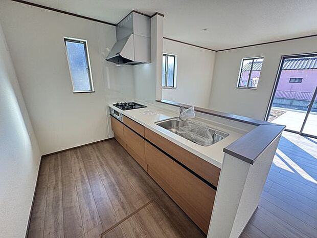 【キッチン/C号棟】木目調のデザインが採用された、LDと一体感のあるキッチンです。上部に吊戸棚などがなく、開放感たっぷり◎