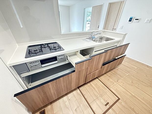 【キッチン】人工大理石トップのシステムキッチン。3口コンロ付きで同時調理が行えます。