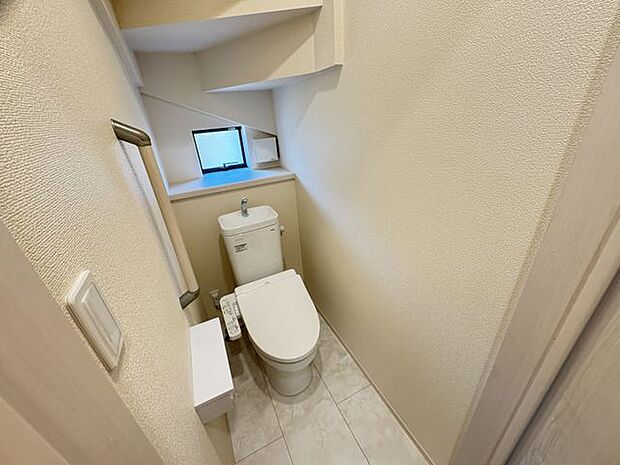 【1階トイレ】小窓や手すり、2連のペーパーホルダーが設置されています。利用中や掃除中に換気を行えるので、いつでも清潔感のある空間を保てそうです。