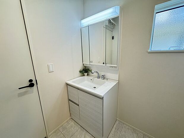 【洗面室】ヘアセットに便利な三面鏡タイプの洗面化粧台が採用されています。