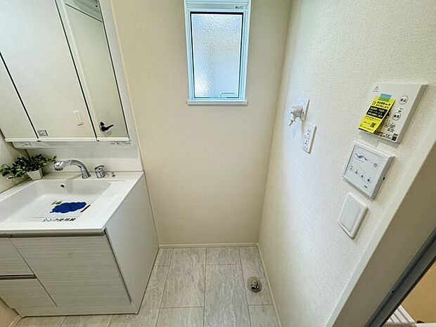 【洗面室】洗面化粧台の隣に洗濯機置き場があります。採光と換気に役立つ小窓付きです。