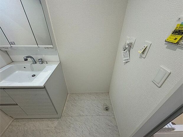 【洗面室】清潔感のある白を基調とした洗面台。コンセント付きで、ドライヤーなどの使用が可能です。