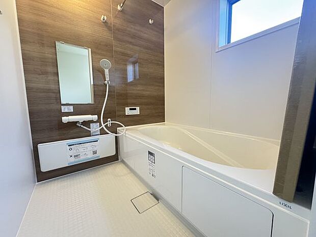 【浴室】ブラウンのアクセントパネルが施された、落ち着いた雰囲気の浴室です。使わない時は折りたためるカウンターが設置されています。