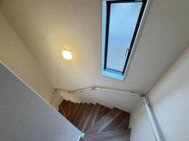 【階段】安全な昇降をサポートする手すり付きです。小窓とライトも設置されています。