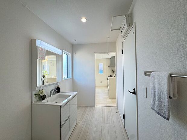 【洗面所】室内干しができるランドリースペースが設けられています。キッチンと洗面所が隣接し、料理をしながら洗濯をしたり、入浴中のご家族の見守りをしたりと、家事動線に配慮されています。